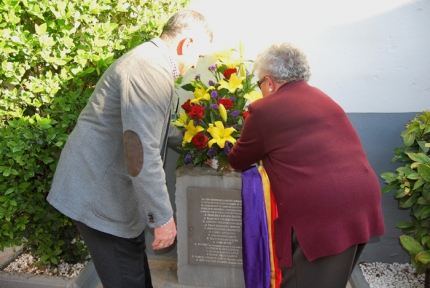 Momento de la ofrenda floral en el monolito de la tapia del cementerio municipal