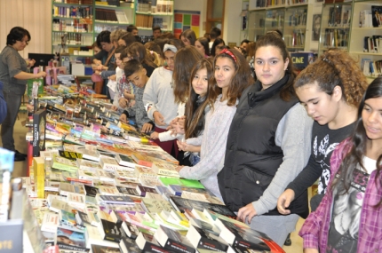 Alumnado del IES Aricel echa un vistazo a los ejemplares expuestos en la feria del libro. 