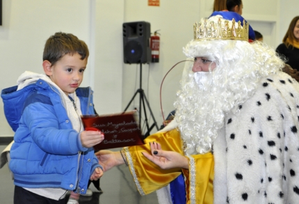 Un pequeño entrega su carta al Rey Melchor. 