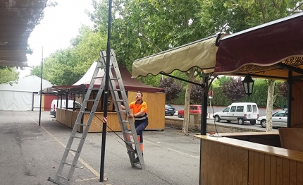 Un operario municipal última el montaje eléctrico en la zona de casetas de la feria de día. 