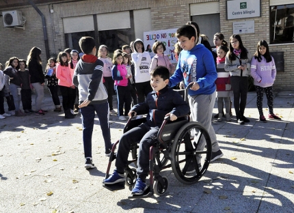 Paseo en silla de ruedas por el patio del colegio, uno de los talleres. 