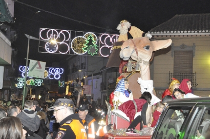 El rey Melchor saluda al público desde su camello durante la cabalgata de Albolote 2018.