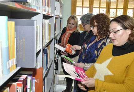 La bibliotecaria Eva Hervás, en primer plano, y la concejala Rosa Madrid, la alcaldesa, Conchi Ramírez y la concejala Montse Bailón, consultan varios ejemplares en la nueva sala de estudio.  