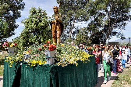 Entrada de la carroza de San Isidro en el paraje de Los Pinos acompañada por numerosos romeros y romeras. 