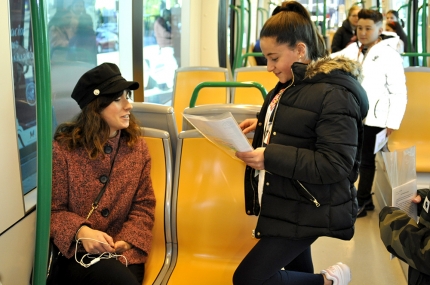 Una alumna lee a una usuaria del metro su cuento. 