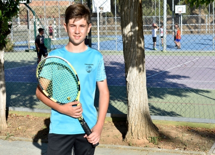 El joven tenista Adrián Lafuente en las pistas del polideportivo con su raqueta. 