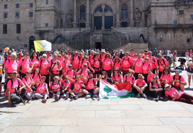 El grupo posa con la bandera de Albolote en la Plaza del Obradoiro con la camiseta conmemorativa de este tercer Camino
