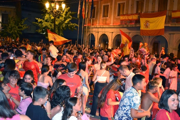 Ambiente en la plaza de España de Albolote tras la finalización del partido. Abajo, un grupo de aficionados de Albolote celebra el triunfo de España.