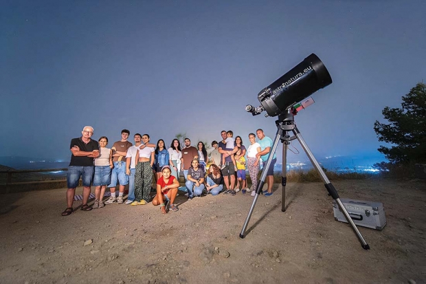 Participantes en el encuentro junto a un potente telescopio en el entorno del Torreón.