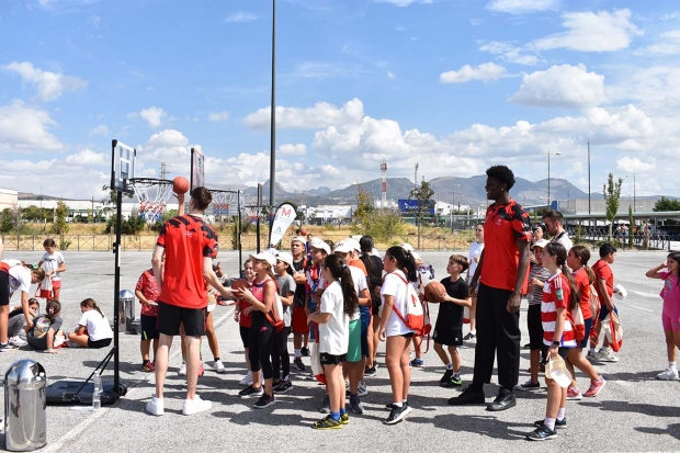 Varios jugadores del Covirán juegan con los escolares del Ave María. Abajo, autoridades locales y provinciales con responsables del Metro reparten obsequios.