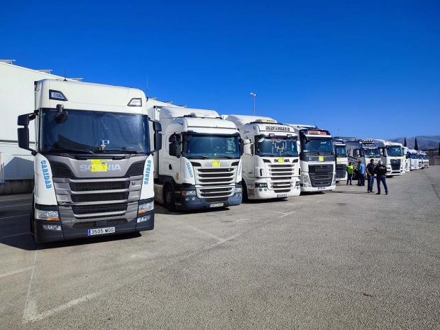 Trailers cargados de material y alimentos antes de partir a tierras valencianas. Abajo, operarios y voluntarios cargan de material uno de los camiones.